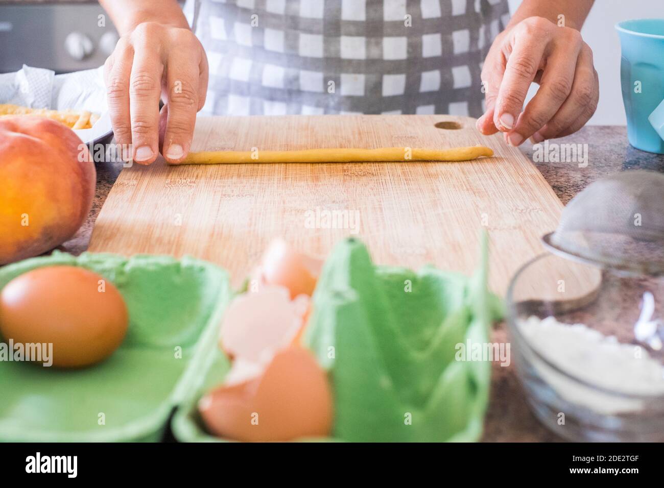 Backtätigkeit zu Hause mit Nahaufnahme der Frau Frau Hände bereitet eine leckere und gesunde natürliche Torte mit farina Und Eier mehr Pfirsich - Lockdown aktiv Stockfoto