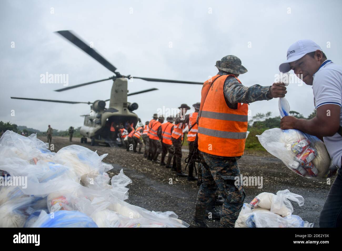 Guatemaltekische Streitkräfte und Zivilisten entladen humanitäre Hilfe von einem Hubschrauber der US-Armee CH-47 Chinook 26. November 2020 in Rubelsanto, Guatemala. Hurrikan Iota fegte durch Mittelamerika und zerstörte große Teile der Küste und überflutete Straßen. Stockfoto