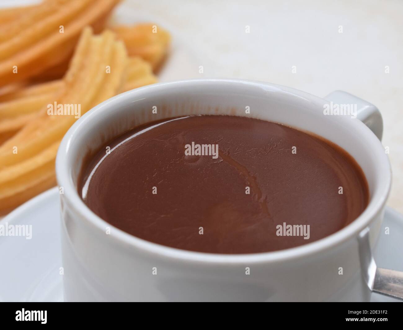 Tasse heiße Schokolade und Churros Stockfoto