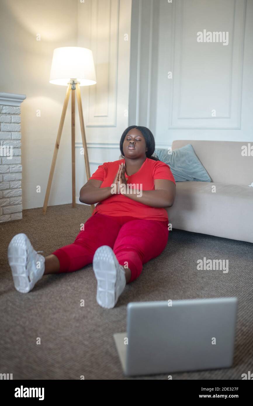 Plus Größe afroamerikanische Frau meditieren und entspannt suchen Stockfoto