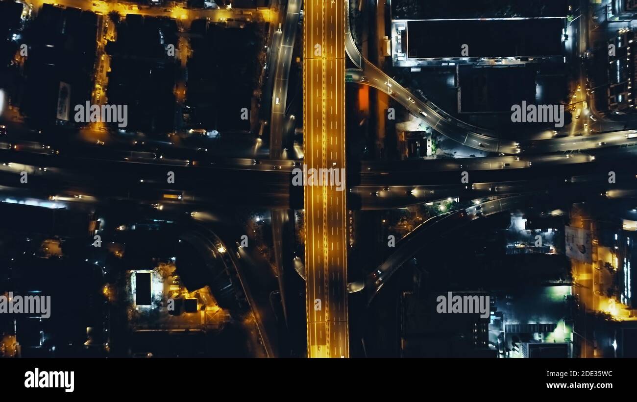 Top down Nacht Stadtverkehr Autobahn an Laternen mit Beleuchtung Stadtbild Luftbild. Downtown Outdoor-Landschaft mit moderner Architektur von Wolkenkratzern Gebäude. Filmische Stadt Philippinen Stockfoto