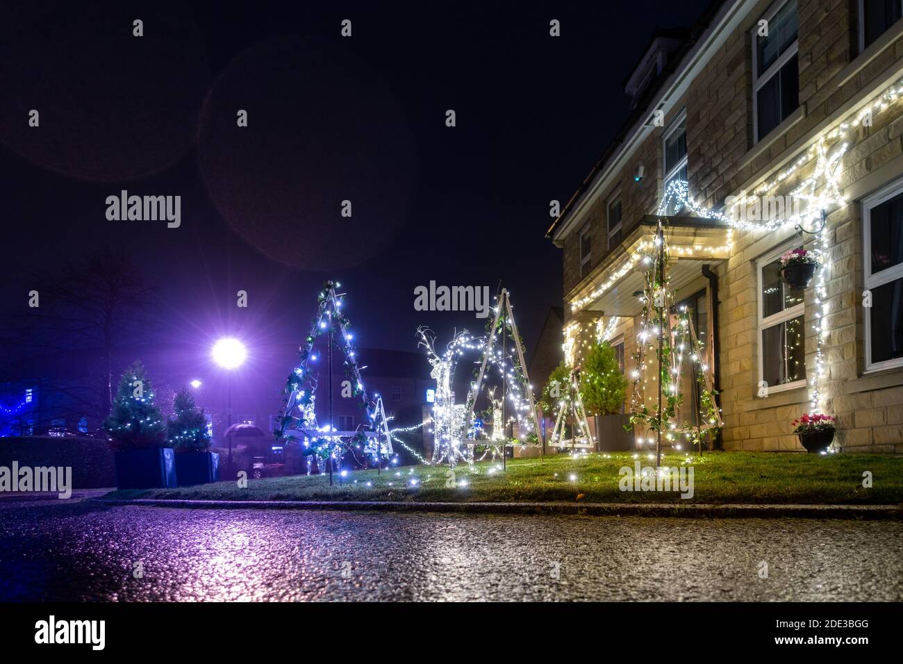 Samstag, 28. November 2020 - WEST YORKSHIRE - Burley-in-Wharfedale Bewohner richten ihre eigenen lokalen Weihnachtsbeleuchtung ein, nachdem sie nicht in der Lage waren, das Hauptdorf Ereignis wegen Tier 3 Einschränkungen zu besuchen. Sie organisierten um 16.30 Uhr einen Streifen der Plug-in-Häuser im ganzen Dorf und trotz des Regens genossen Familien es, von den Fenstern aus zuzuschauen und herumherzulaufen, und genossen die Bemühungen, die Menschen unternommen hatten, um lokale festliche Stimmung zu schaffen. West Yorkshire Rebecca Cole (c) Alamy Live Nachrichten Stockfoto