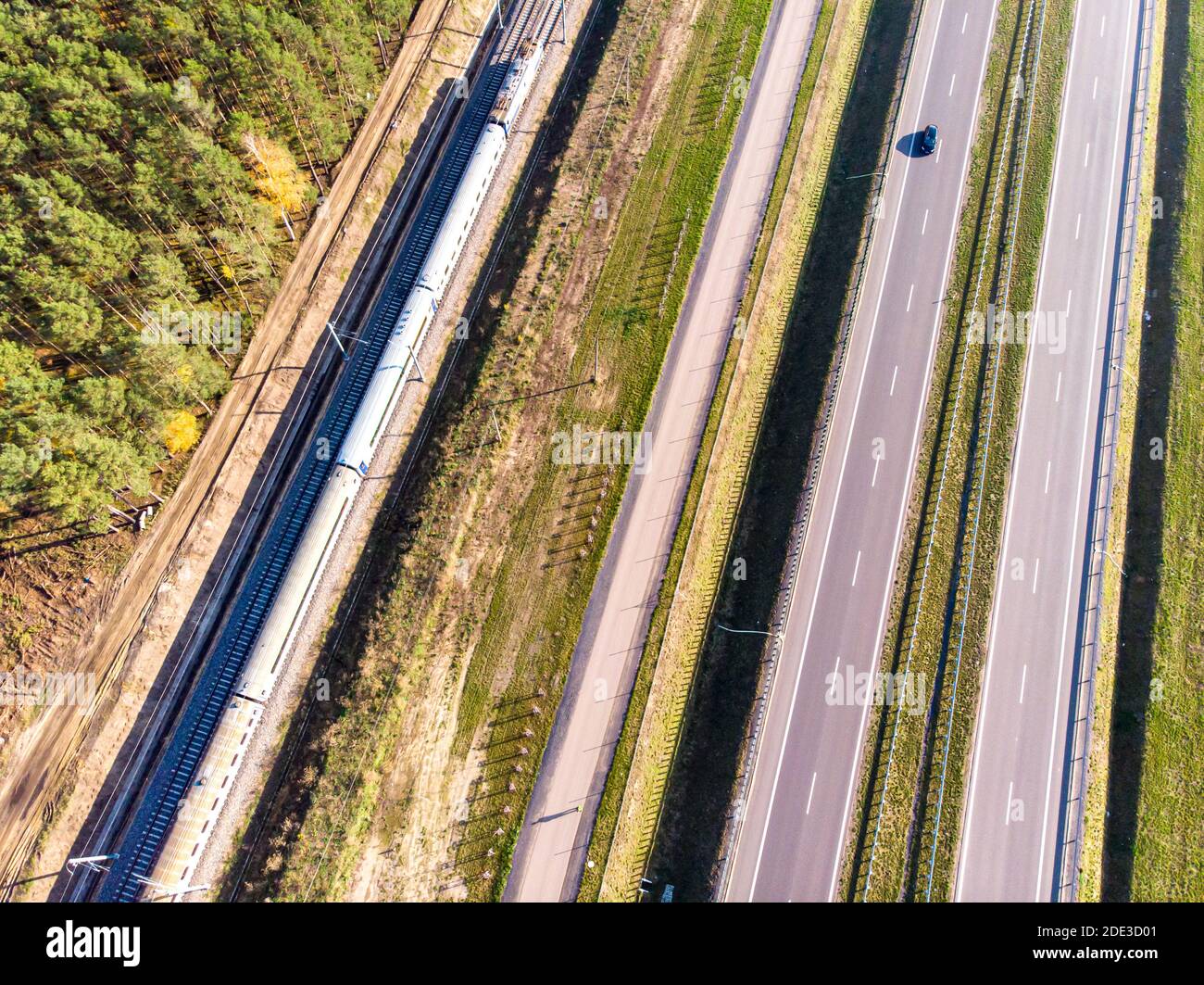 Vier Fahrspuren der Schnellstraße, die innere Fahrspur und die Gleise, aus Vogelperspektive gesehen Stockfoto