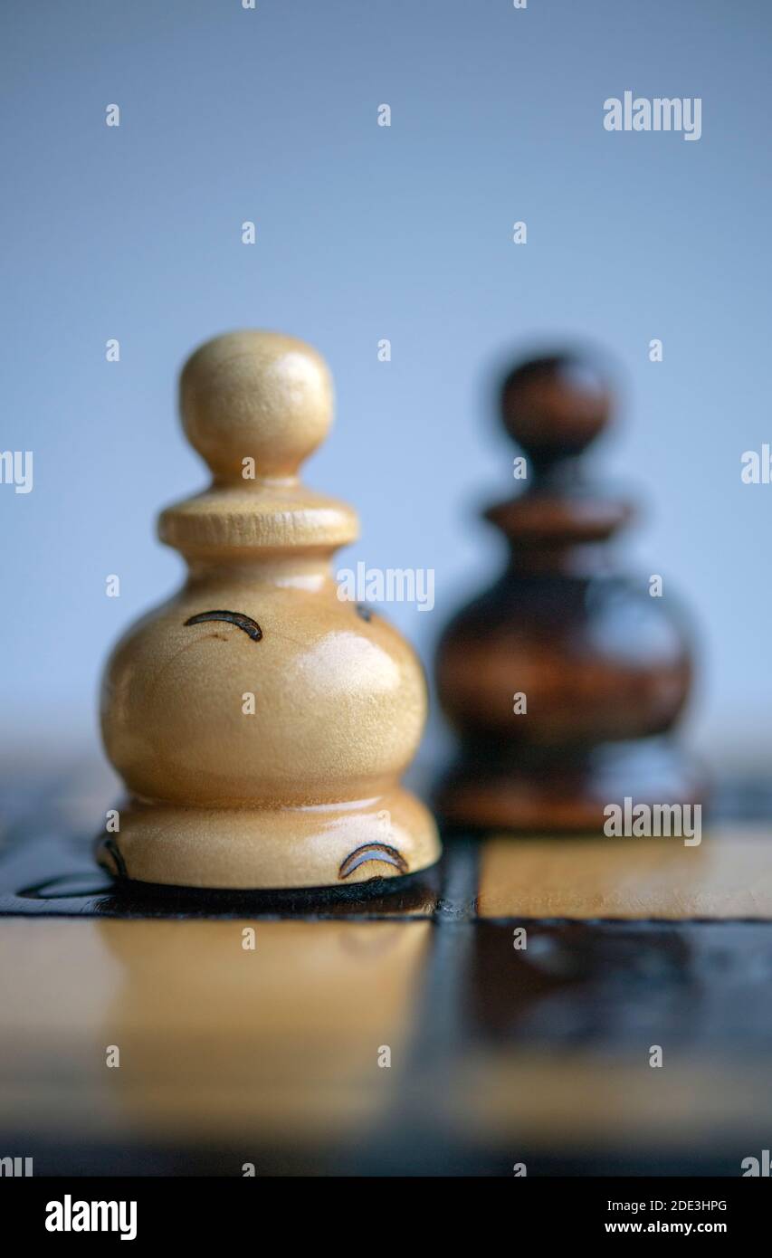 Schwarze und weiße Bauern auf einem Schachbrett Stockfoto
