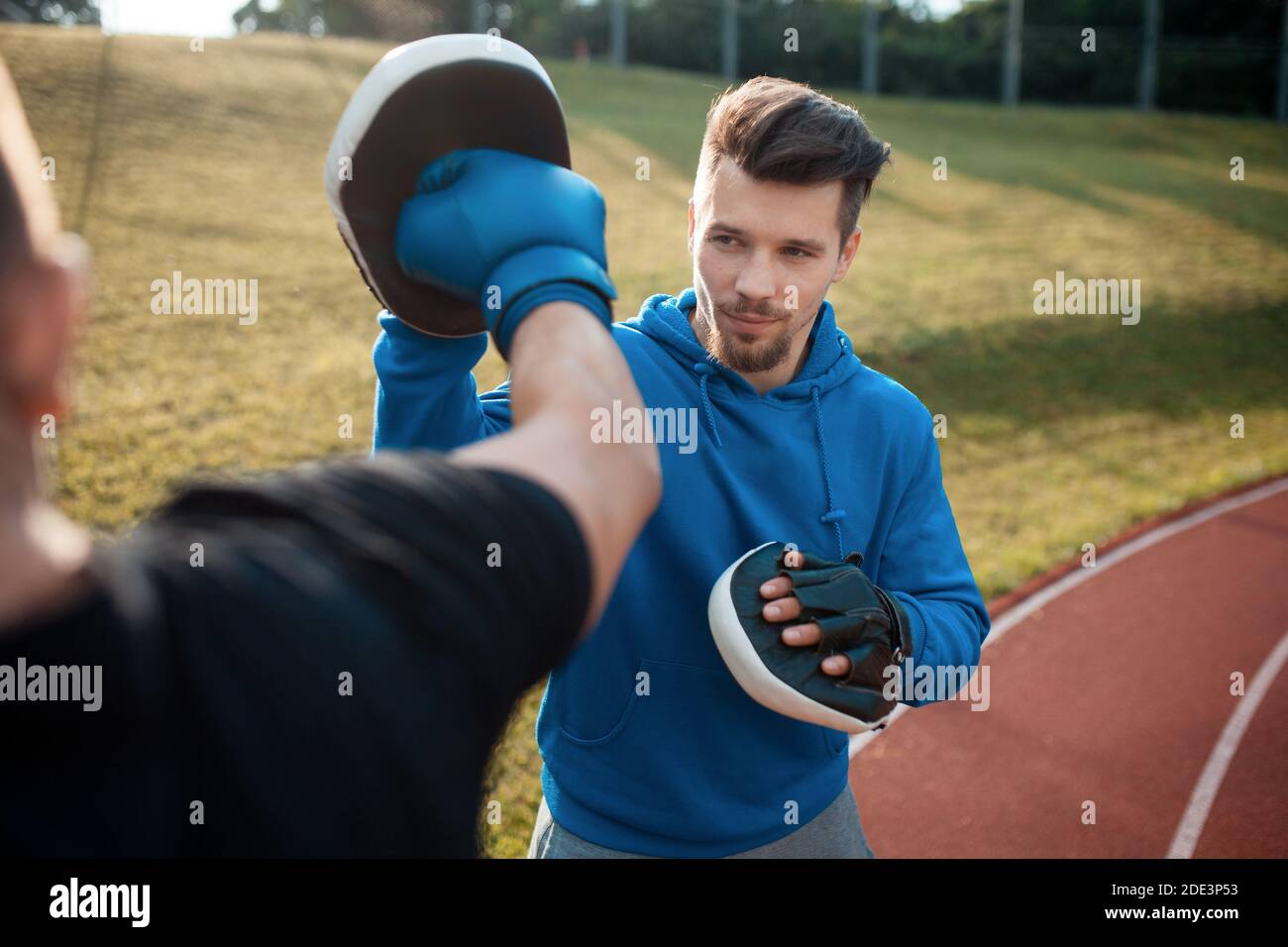 Sport Mann Boxen und Training in Boxhandschuhen mit persönlichen Fitnesstrainer Stockfoto