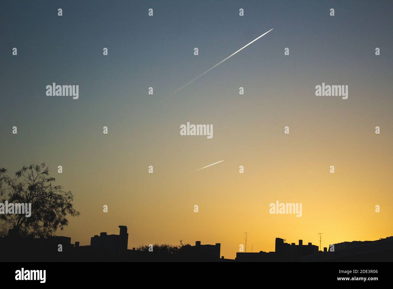 Flugzeuge am Himmel mit Skyline bei Sonnenuntergang in madrid Stockfoto