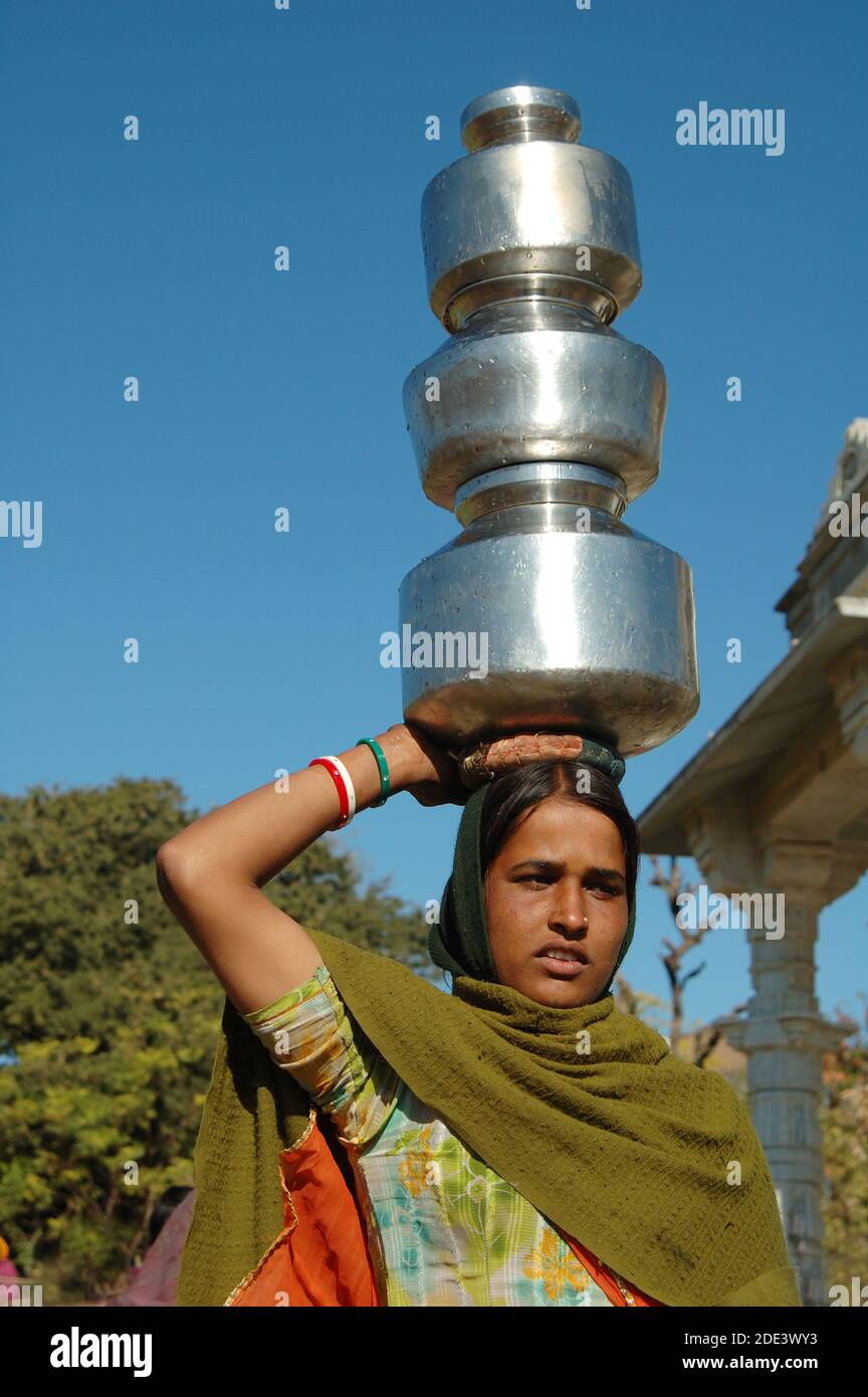 Junge Frau tragen Wasser auf ihren Köpfen Rajasthan, Indien Stockfoto