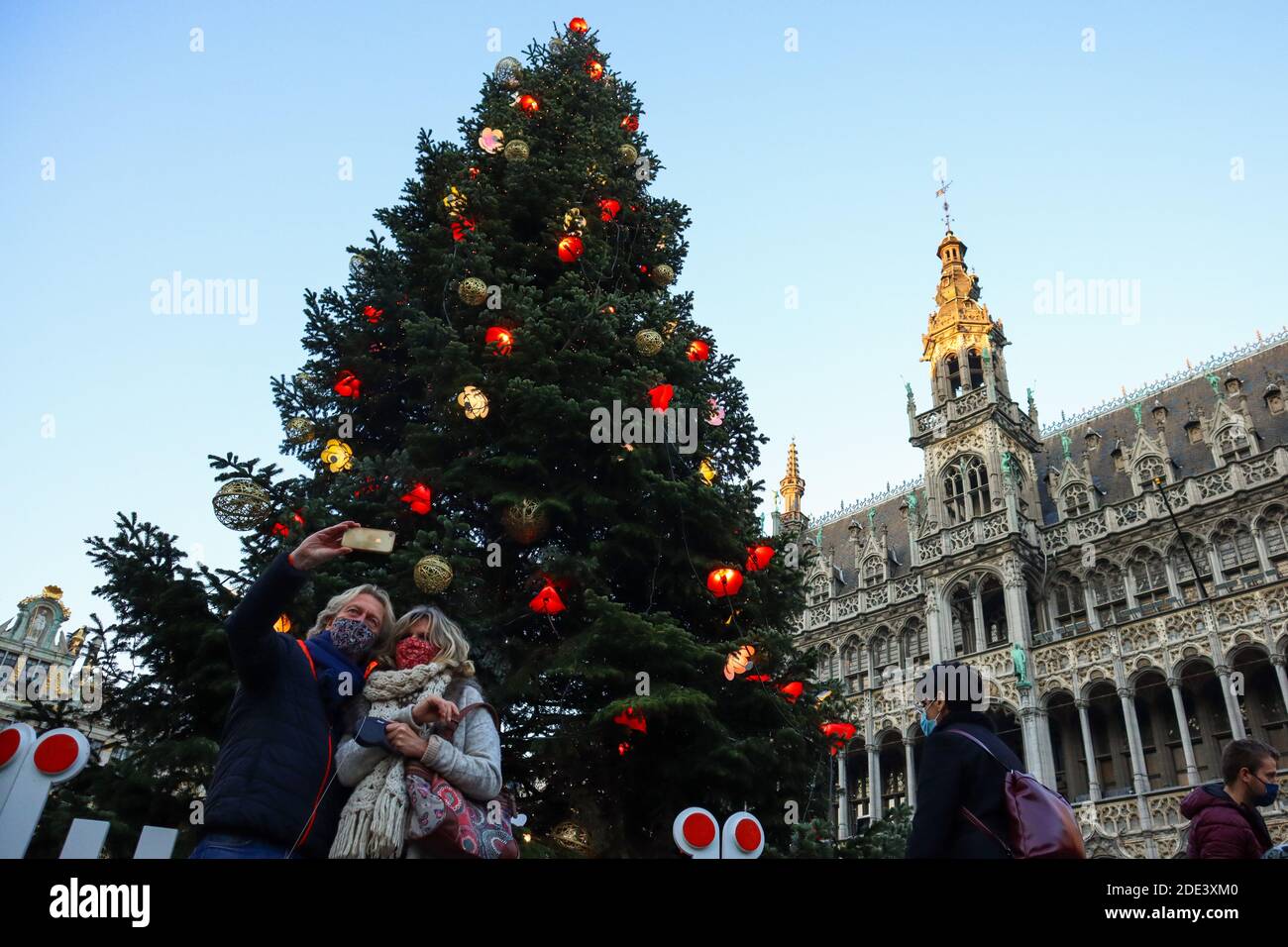 Brüssel, Belgien. November 2020. Am 28. November 2020 posieren Menschen für Fotos mit einem Weihnachtsbaum auf dem Grand Place in Brüssel, Belgien. Der Weihnachtsbaum am Grand Place von Brüssel wurde in diesem Jahr mit dem Thema "neu" dekoriert. Quelle: Zheng Huansong/Xinhua/Alamy Live News Stockfoto