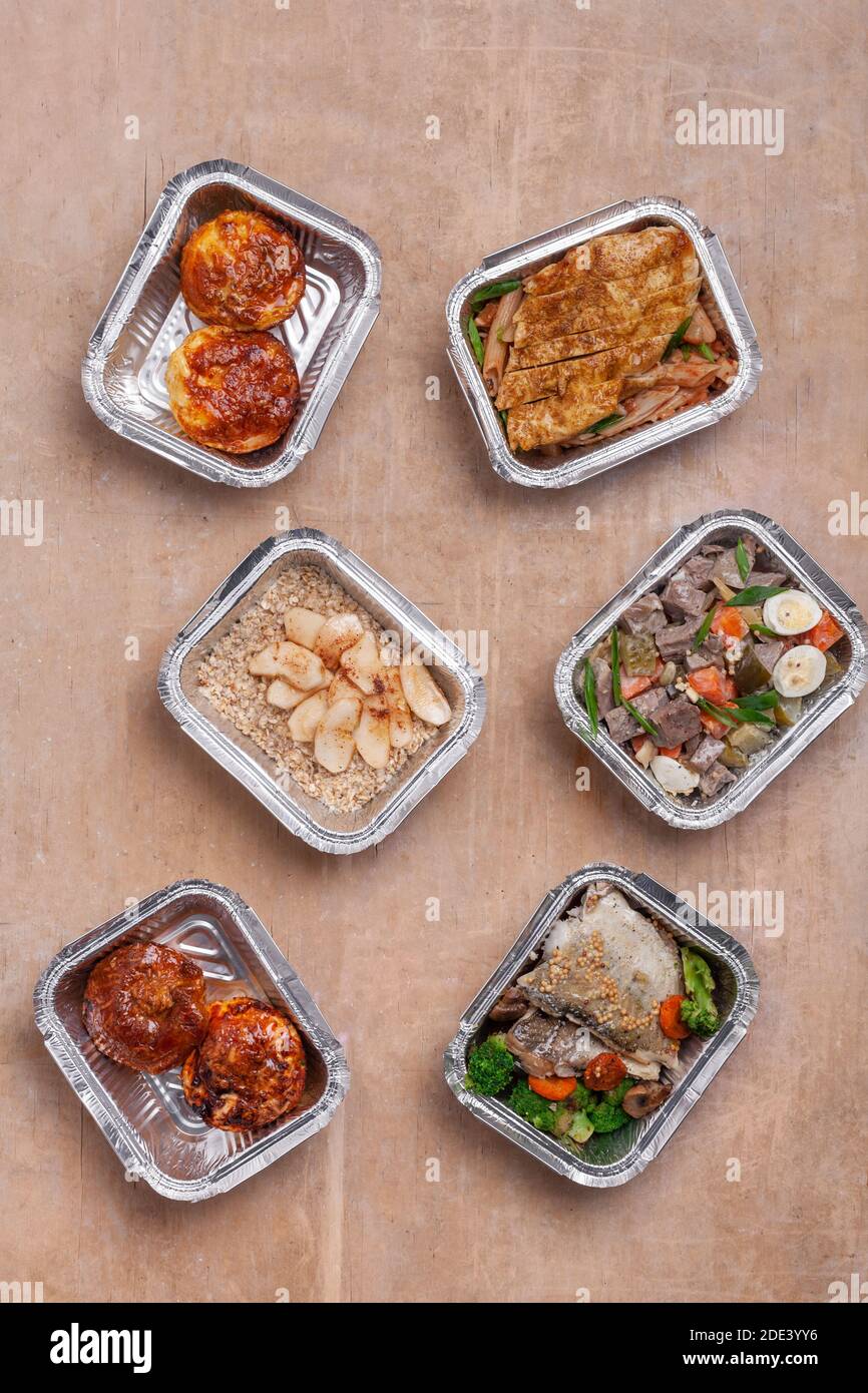 Lunchboxen zum Mitnehmen mit frischem Essen in Folienbehälter Oder gesunde Lieferung von Lebensmitteln Stockfoto