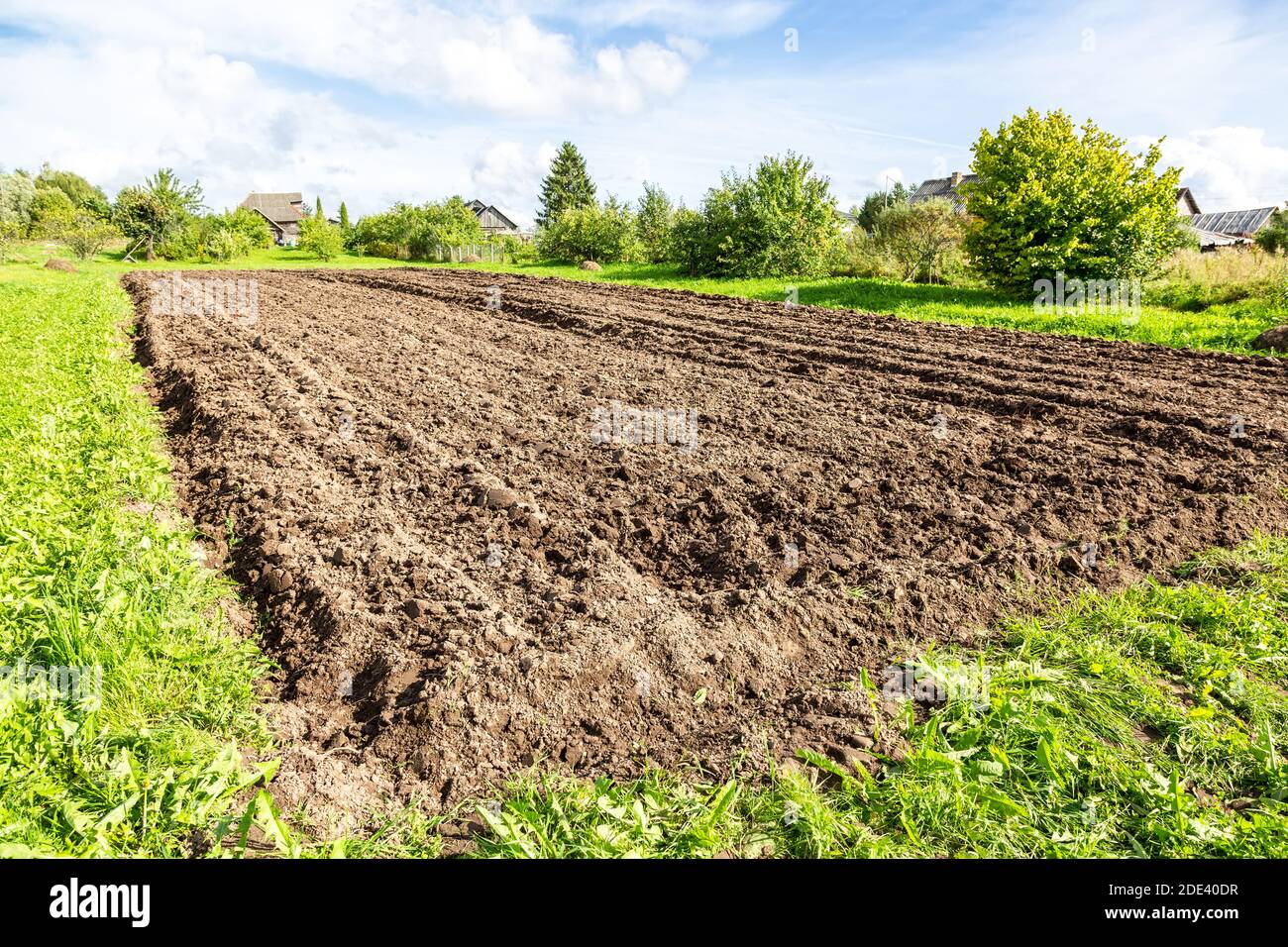 Frisch gepflügte landwirtschaftliche Feld auf dem Land im sonnigen Sommer Tag Stockfoto