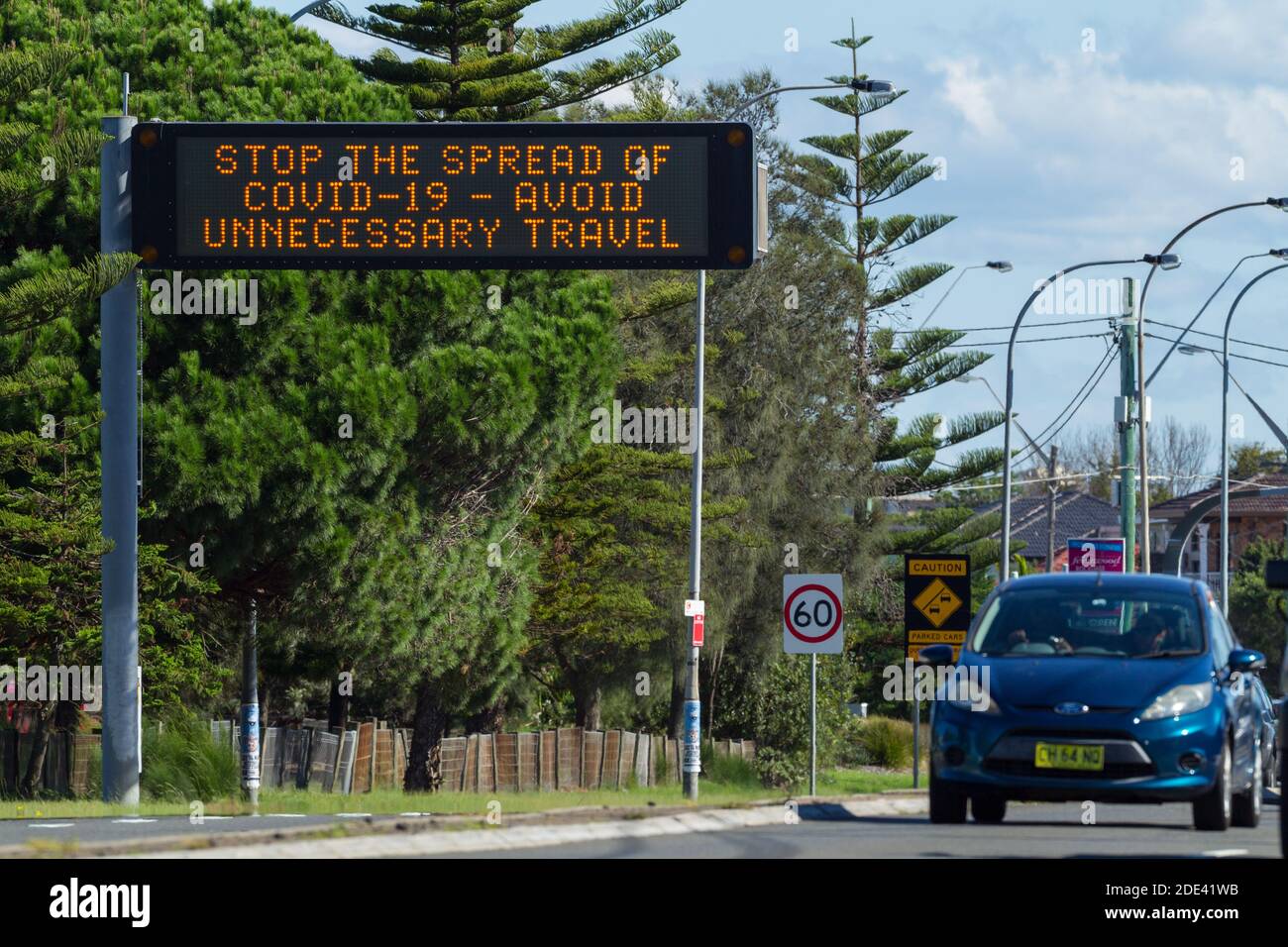 Verkehr auf dem General Holmes Drive in Kyeemagh an der Botany Bay in der Nähe des Flughafens Sydney in Sydney, Australien, mit einem öffentlichen Hinweisschild, das vor den Risiken unnötiger Reisen während der COVID-19 Coronavirus-Pandemie warnt. Stockfoto