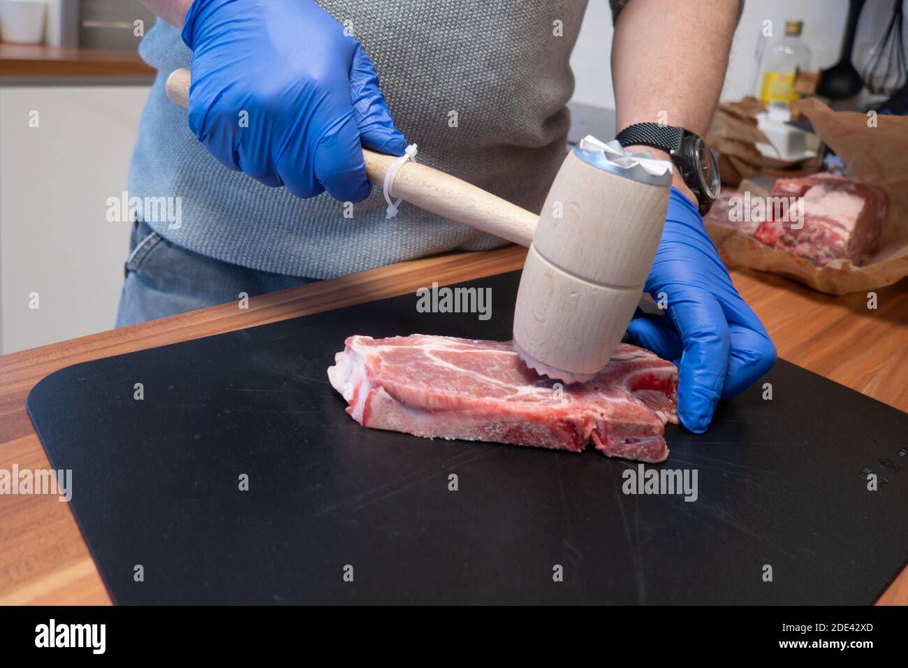 Ein Schnitzel wird mit einem Quirl weich geschlagen Stockfoto