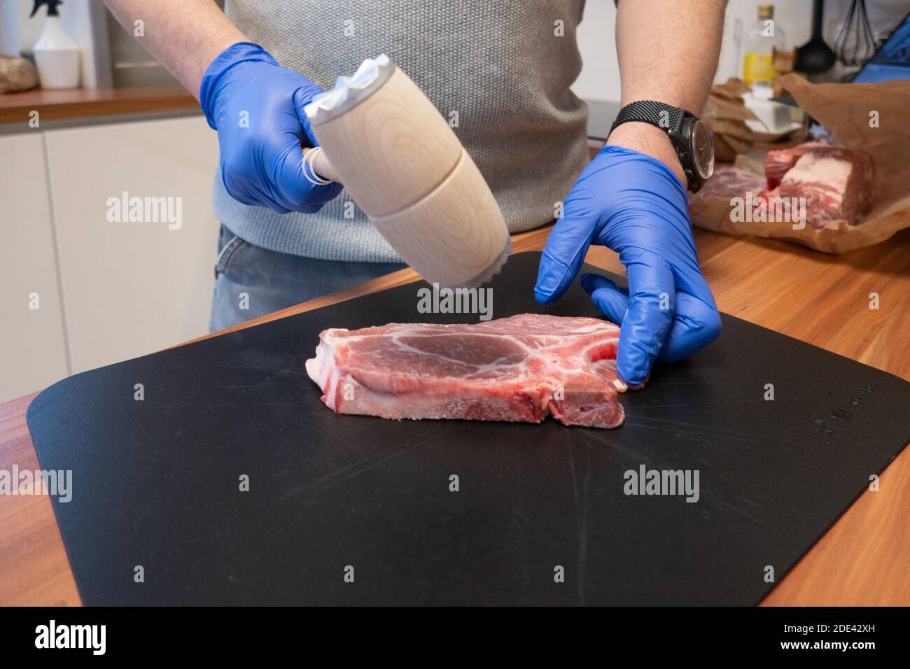 Ein Schnitzel wird mit einem Quirl weich geschlagen Stockfoto