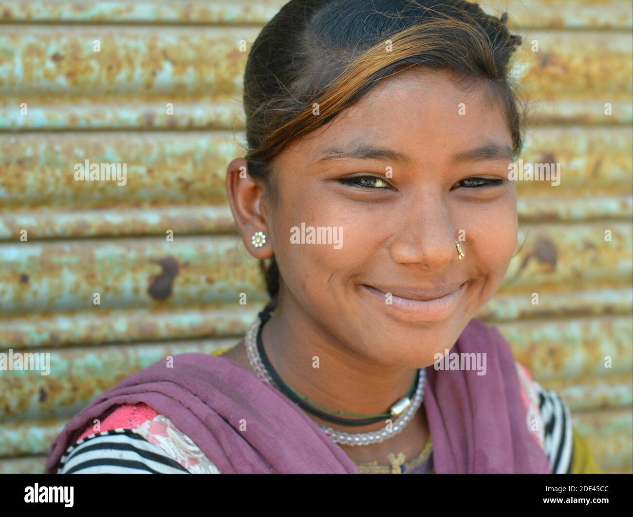 Fröhliche ziemlich schelmisch indischen Gujarati Teenager-Mädchen aus Kutch mit Wangendippen und gefärbten Strang von Haaren lächelt für die Kamera. Stockfoto