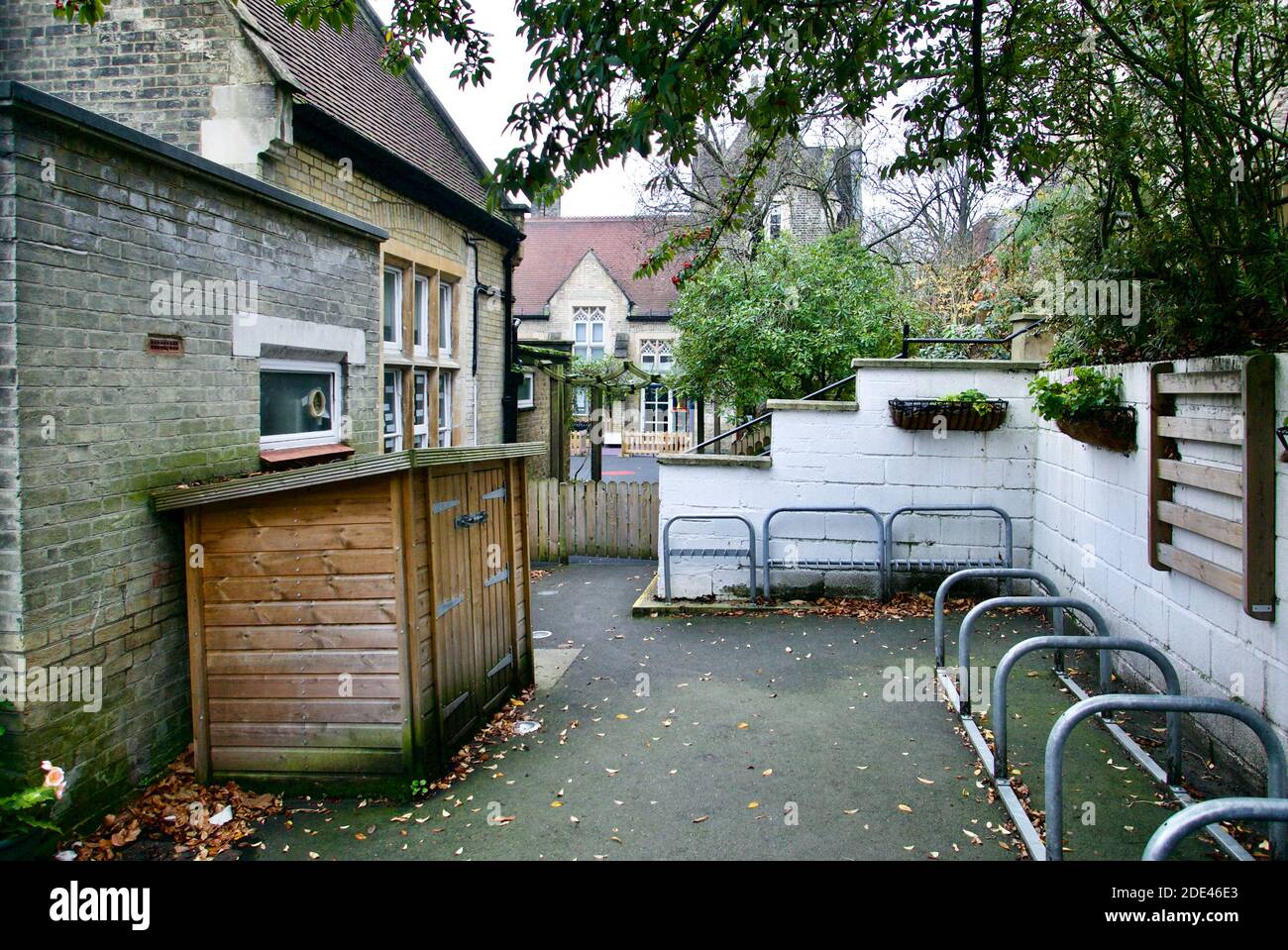 Christ Church Primary School in Hampstead Village, London. Eine staatliche Einformschule in Camden mit leerem Spielplatz und Fahrraddepot. Stockfoto