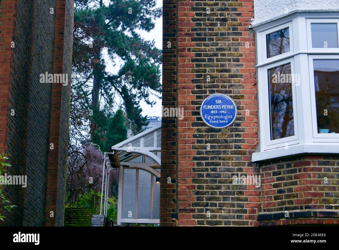 Sir Flinders Petrie Ägyptologe blaue Plakette von English Heritage in Hampstead Village, London an einem Ende eines Reihenhauses. Stockfoto