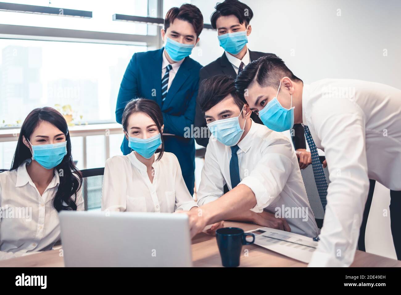 Geschäftsleute tragen Gesichtsmaske und Business Meeting in modernen Office während Pandemie des Virus Stockfoto