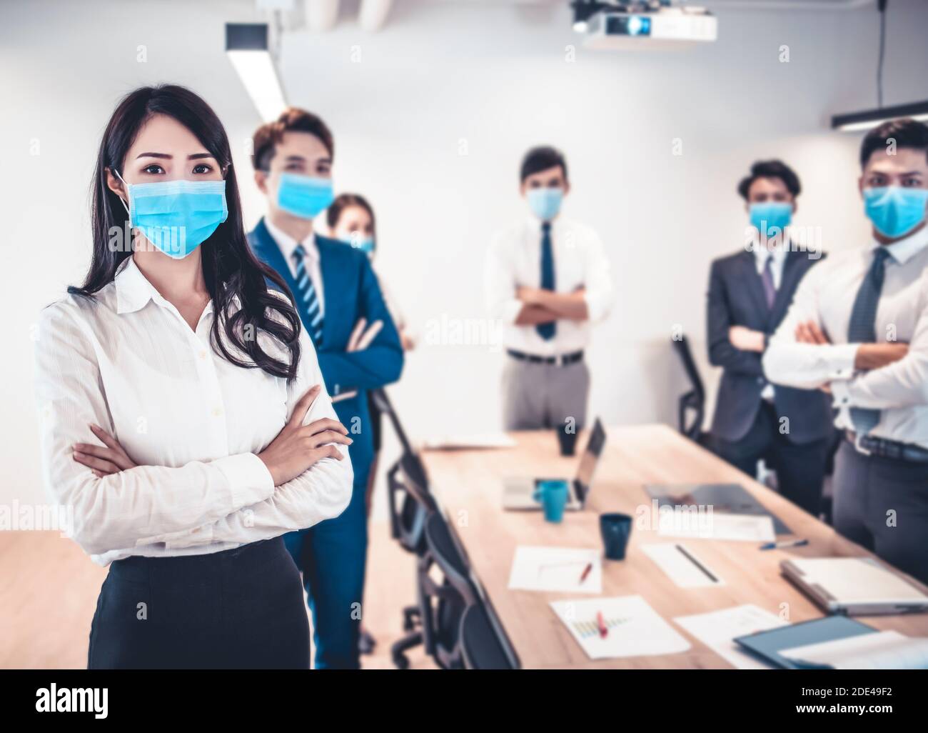 Geschäftsleute tragen Gesichtsmaske mit Präsentation der Business-Plan. Geschäftstreffen im modernen Büro während Pandemie des Virus Stockfoto