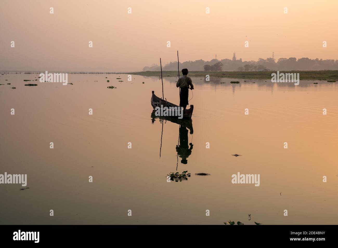 Fischer steht mit Boot auf dem Taung Tha man See zum Sonnenaufgang, Reflexion im Wasser, Thaung Tha man See, Mandalay, Myanmar Stockfoto