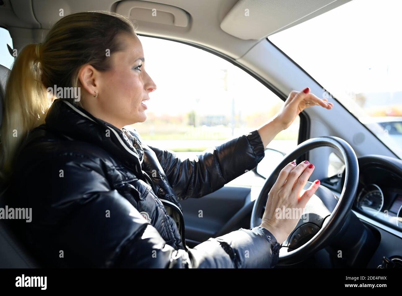 Junge Frau am Steuer, aggressiv, hupend und gestikulierend wild, Stuttgart, Baden-Württemberg, Deutschland Stockfoto