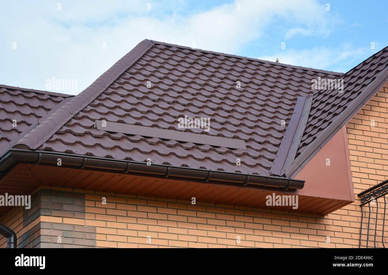 Wasserabdichtung Dachproblematik mit Metalldachblechen und Regenrinne. Leichte Dachziegel aus Metall Dachkonstruktion. Stockfoto