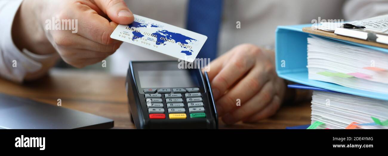 Büroangestellte zeigt Kreditkarte und Terminal Stockfoto