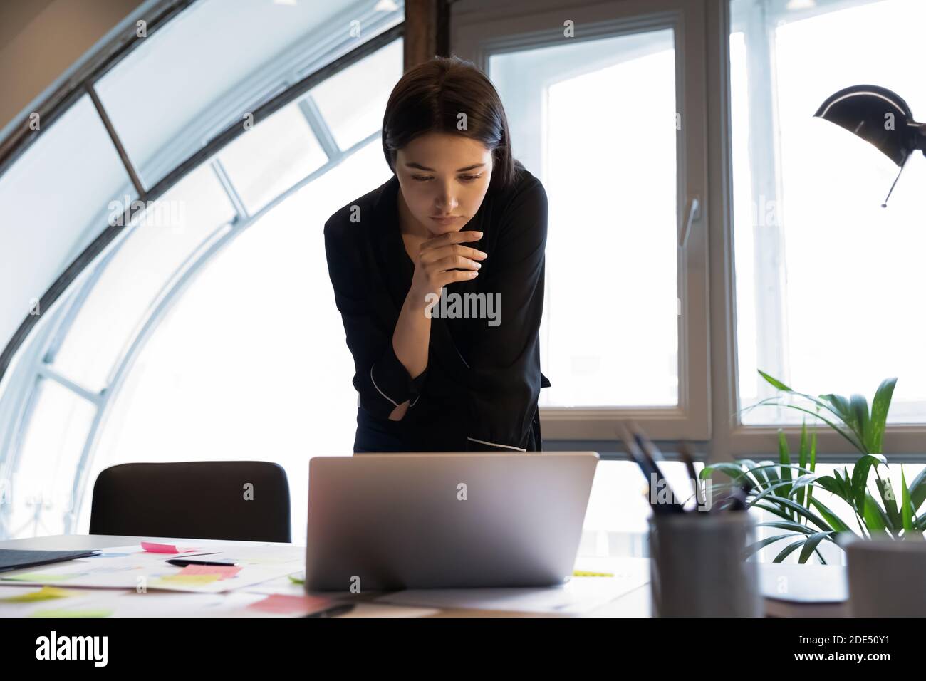 Pensive gemischte Rennen Dame Daten Analyst auf Laptop-Bildschirm suchen Stockfoto