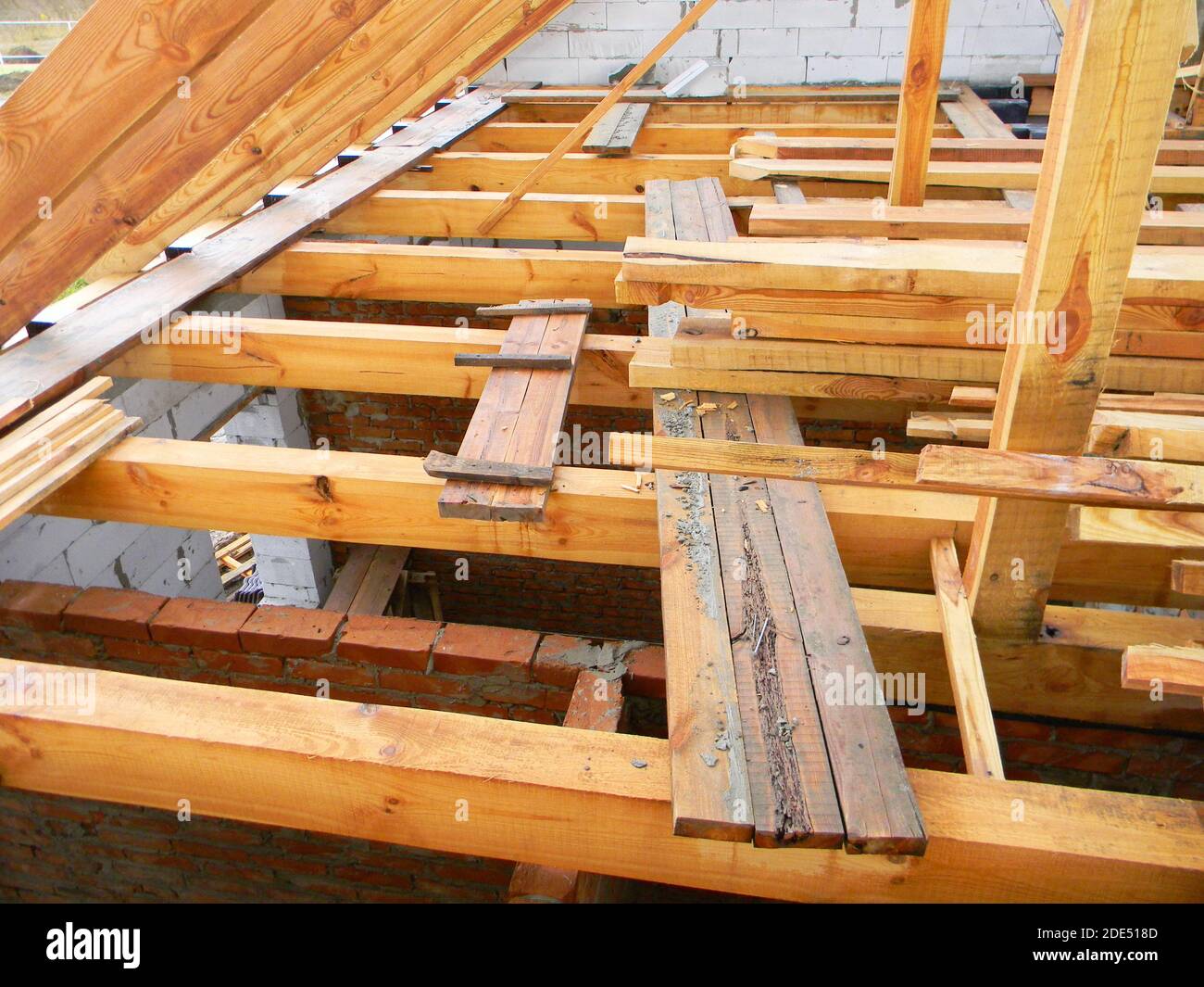 Unvollendete Dachdachkonstruktion mit Dachstühlen, Holzbalken, Dachrinnen, Holz. Haus Dach Holzrahmen Konstruktion. Stockfoto