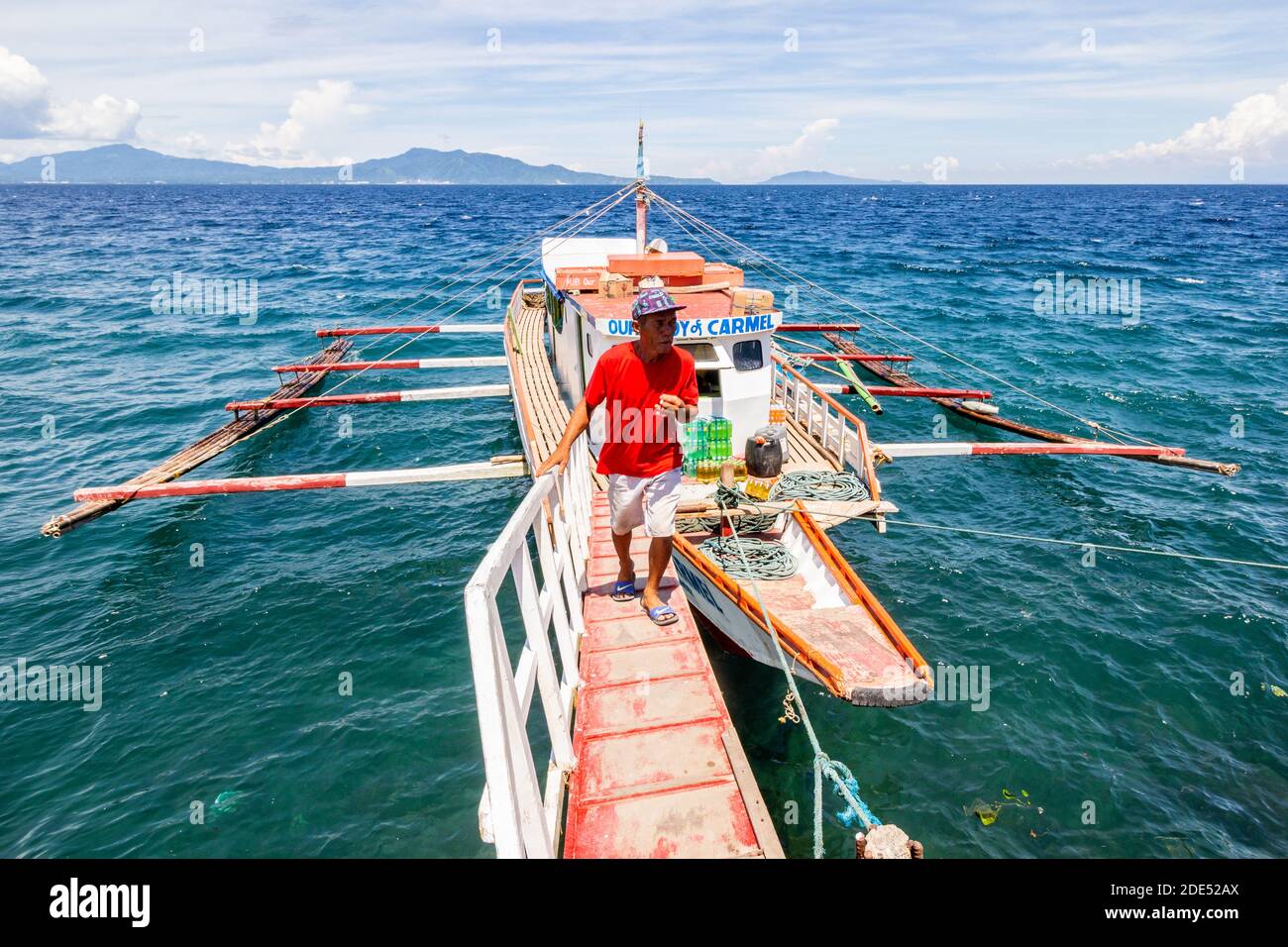 Ein philippinischer Mann, der von einem Auslegerboot in Batangas, Philippinen, läuft Stockfoto