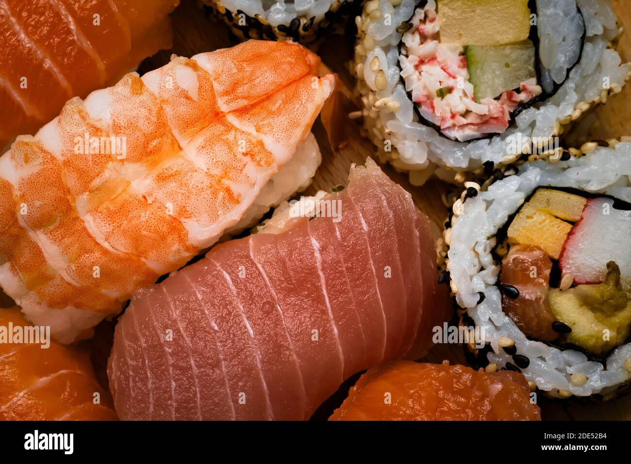 Frische und Gourmet Sushi Maki-Brötchen gefüllt mit Wildlachs Sashimi und Sushi Nigiri drapiert mit Lachs, Thunfisch und Garnelen Stockfoto