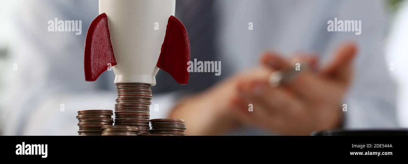 Makro-Foto auf kleine Rakete, die auf Münzen stehen Stockfoto