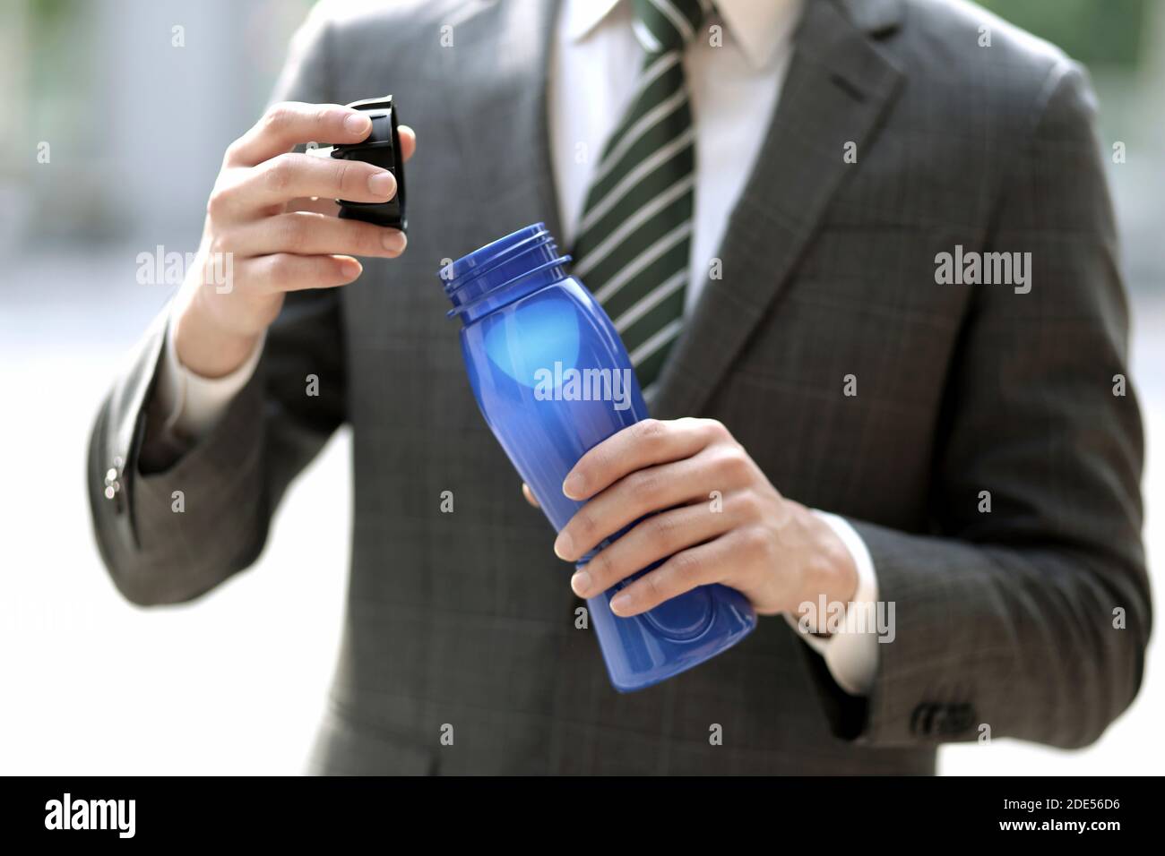 Nahaufnahme eines Geschäftsmannes, der eine Flasche Wasser hält Stockfoto