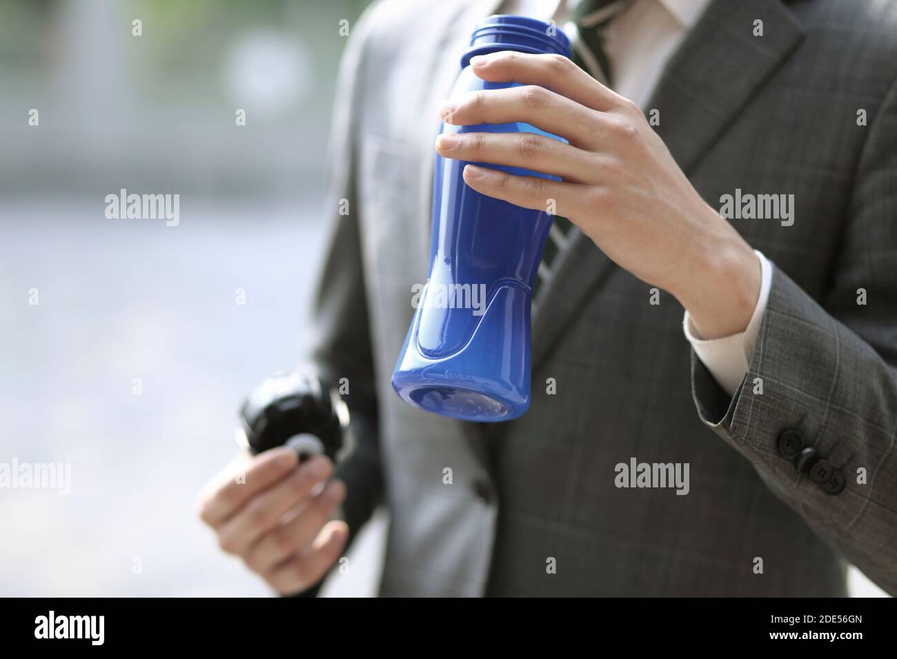 Nahaufnahme eines Geschäftsmannes, der eine Flasche Wasser hält Stockfoto