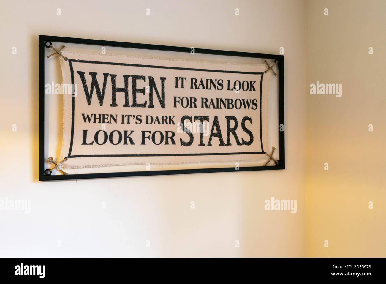 Inspiration Zitat When IT Rains Suchen Sie nach Rainbows When ITS Dark nach Stars. Minimalistisches Canvas, das von einem Metallrahmen gehalten wird. Motivations-Slogan. Zu Hause Stockfoto