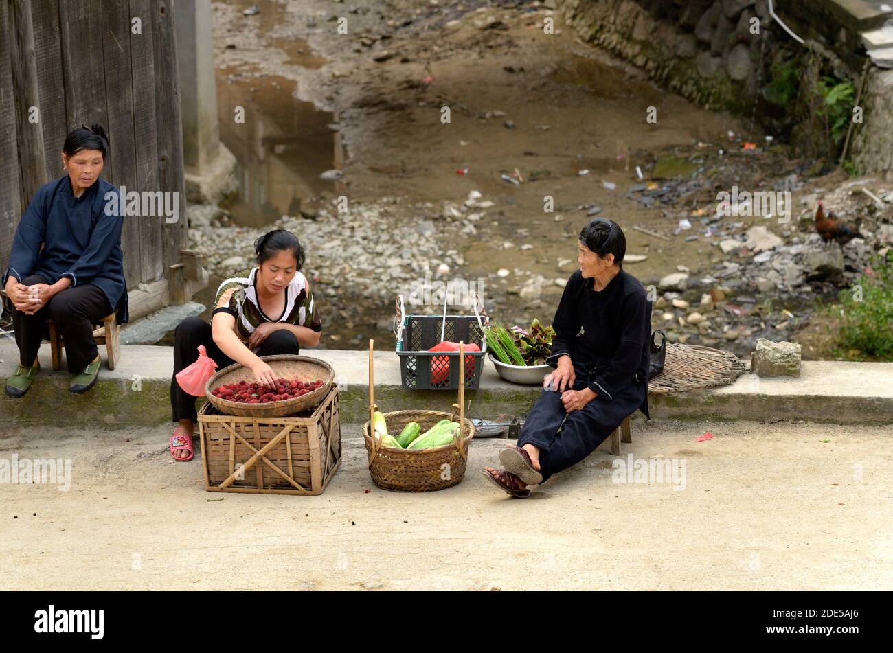 ZHAOXING DONG, CHINA - Juni 21, 2012: Chinesische Miao-minorität Frauen verkaufen frische Himbeeren fruitsand Gemüse auf der Straße. Stockfoto