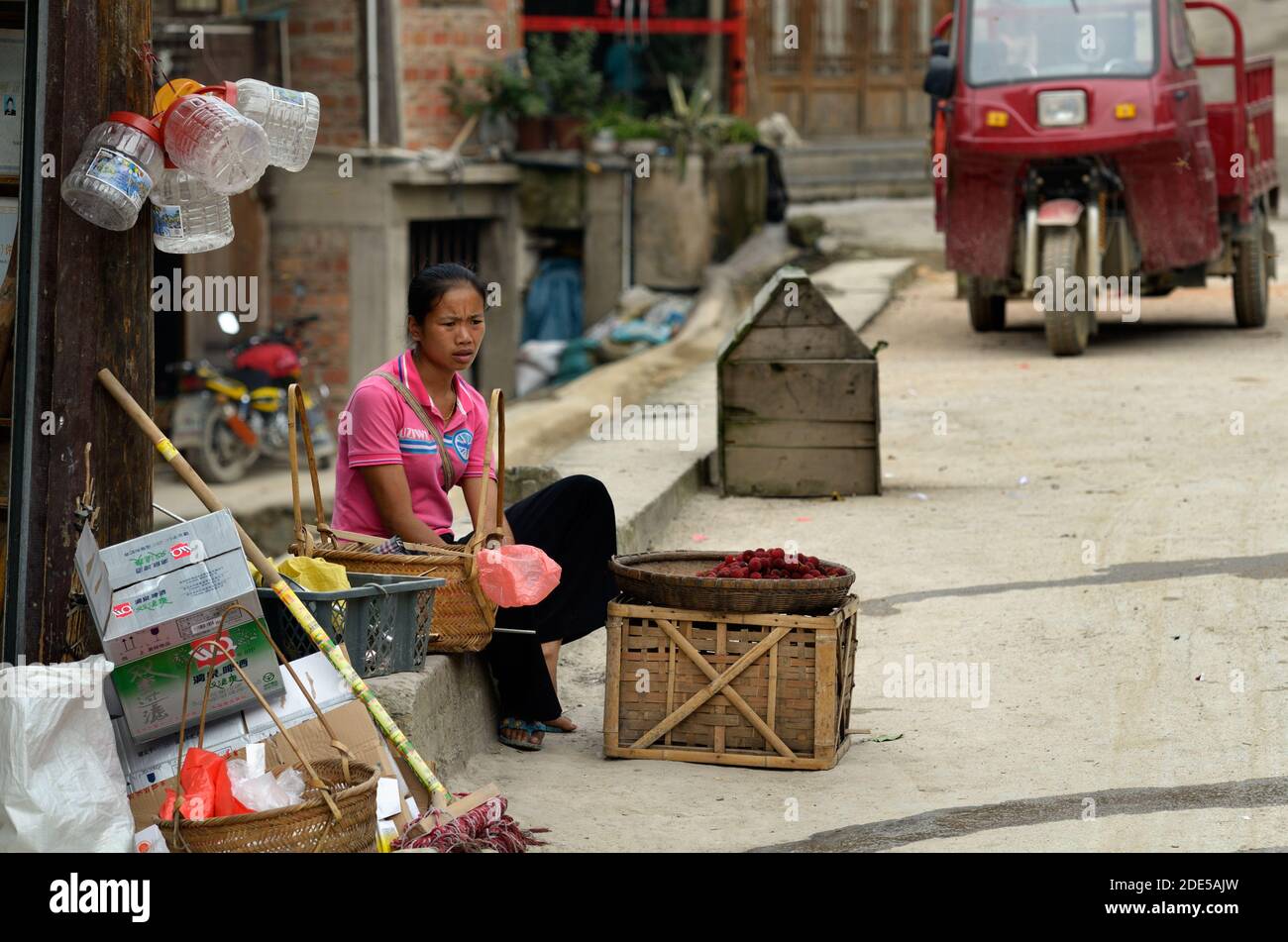 ZHAOXING DONG, CHINA - Juni 21, 2012: Chinesische Miao-minorität Frau verkaufen frische Himbeeren Obst in der Straße. Stockfoto