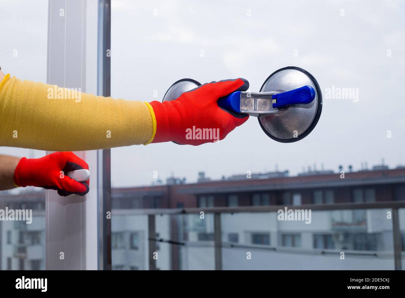 Nahaufnahmen. Glasurglas, das das Glas mit einem Saugnapf hält, während das Fenster installiert wird Stockfoto