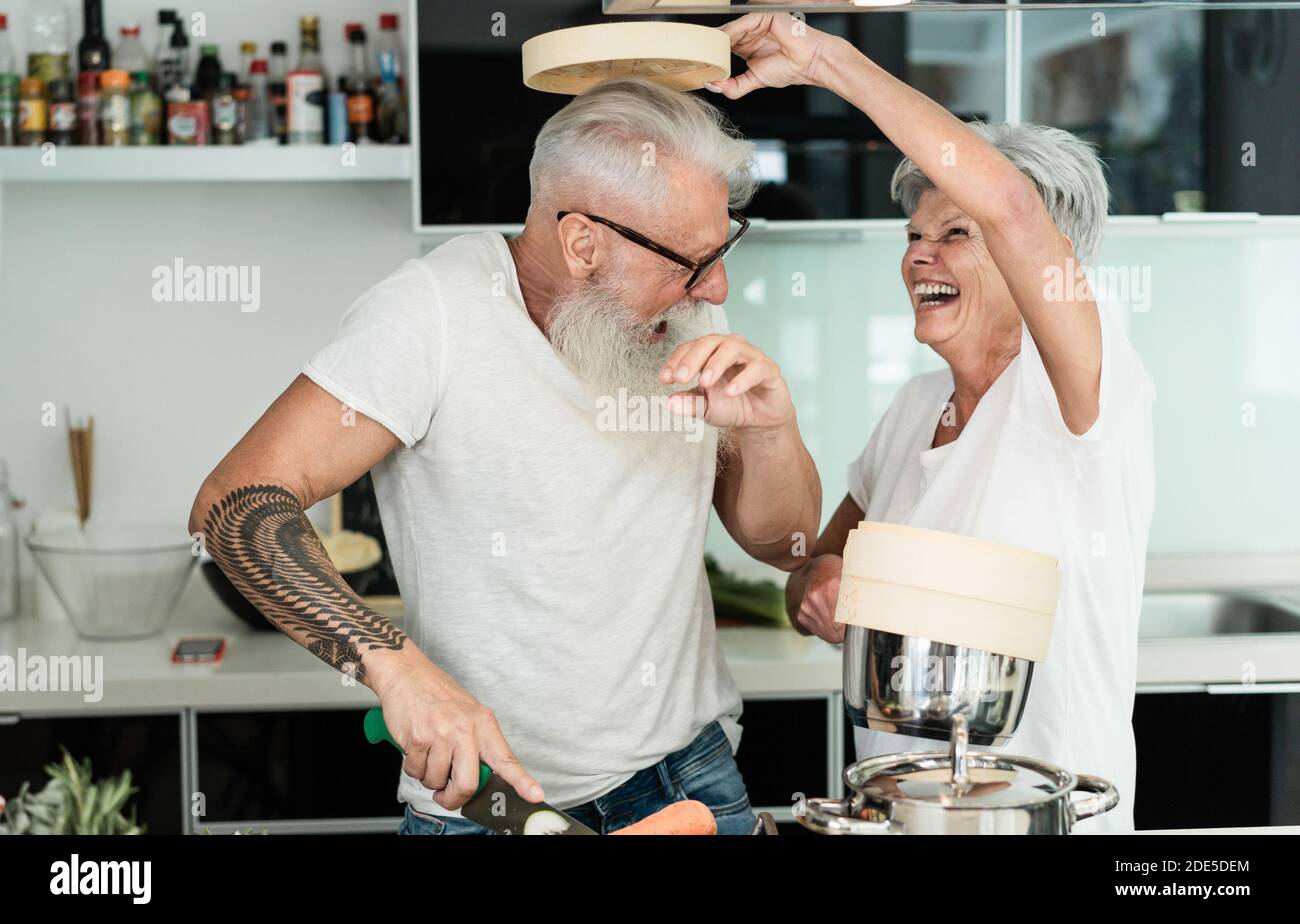 Verrückte ältere Paar Kochen zusammen zu Hause - freudige ältere Menschen Lifestyle und Ernährung Konzept - Schwerpunkt auf den Menschen Gesicht Stockfoto