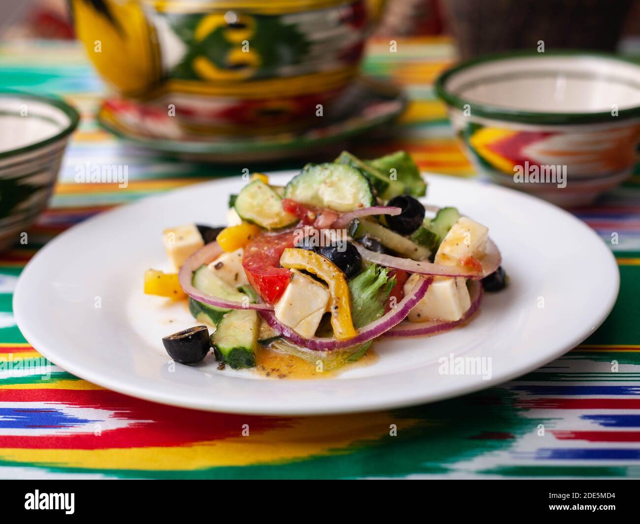 Warmer Salat aus grünen und roten Paprika, Käse, Auberginen, Zwiebeln und Tomaten im asiatischen Stil Stockfoto