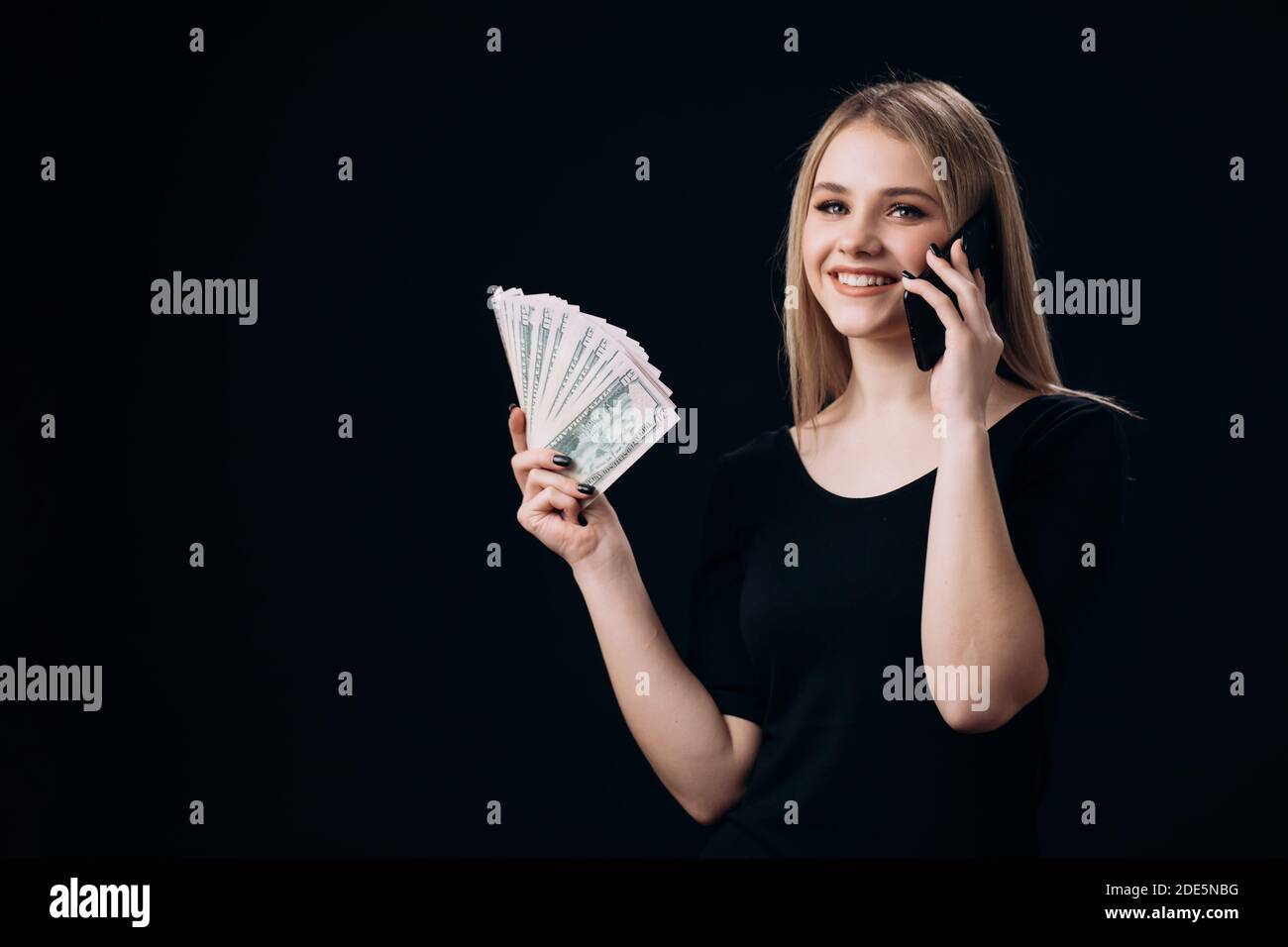 Frau mit Geld Bargeld mit Handy reden Stockfoto