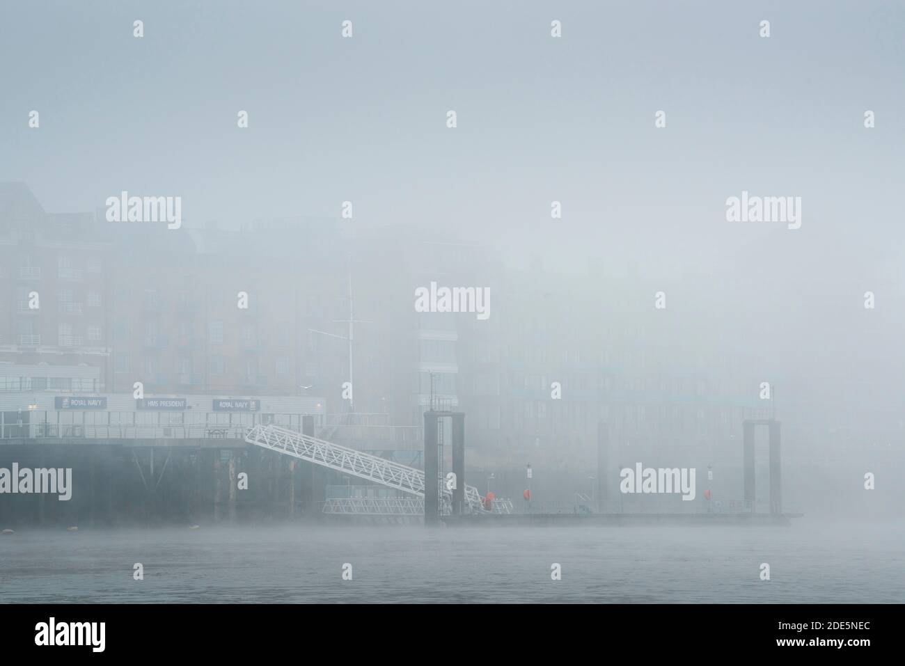 HMS President Royal Navy Reserve Pier und Themse im dichten Nebel und Nebel bei nebligen und nebligen Wetter während Covid-19 Coronavirus Lockdown, England, Großbritannien Stockfoto