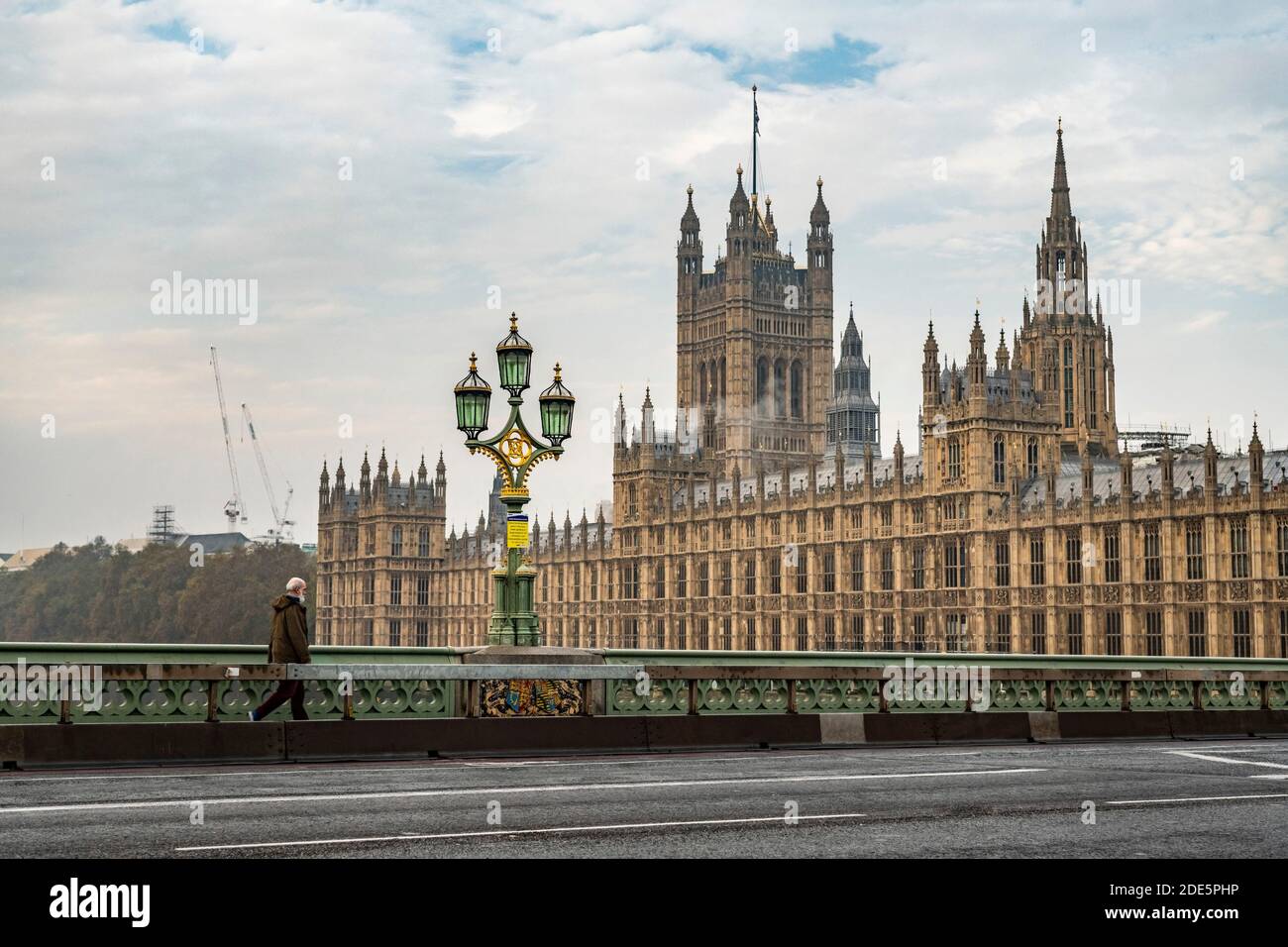 London in Coronavirus Covid-19 Absperrung, ruhig mit leeren Straßen und Straßen mit fast keiner Person, nur eine Person pendelt, mit Houses of Parliament in England, Großbritannien zur Hauptverkehrszeit Stockfoto