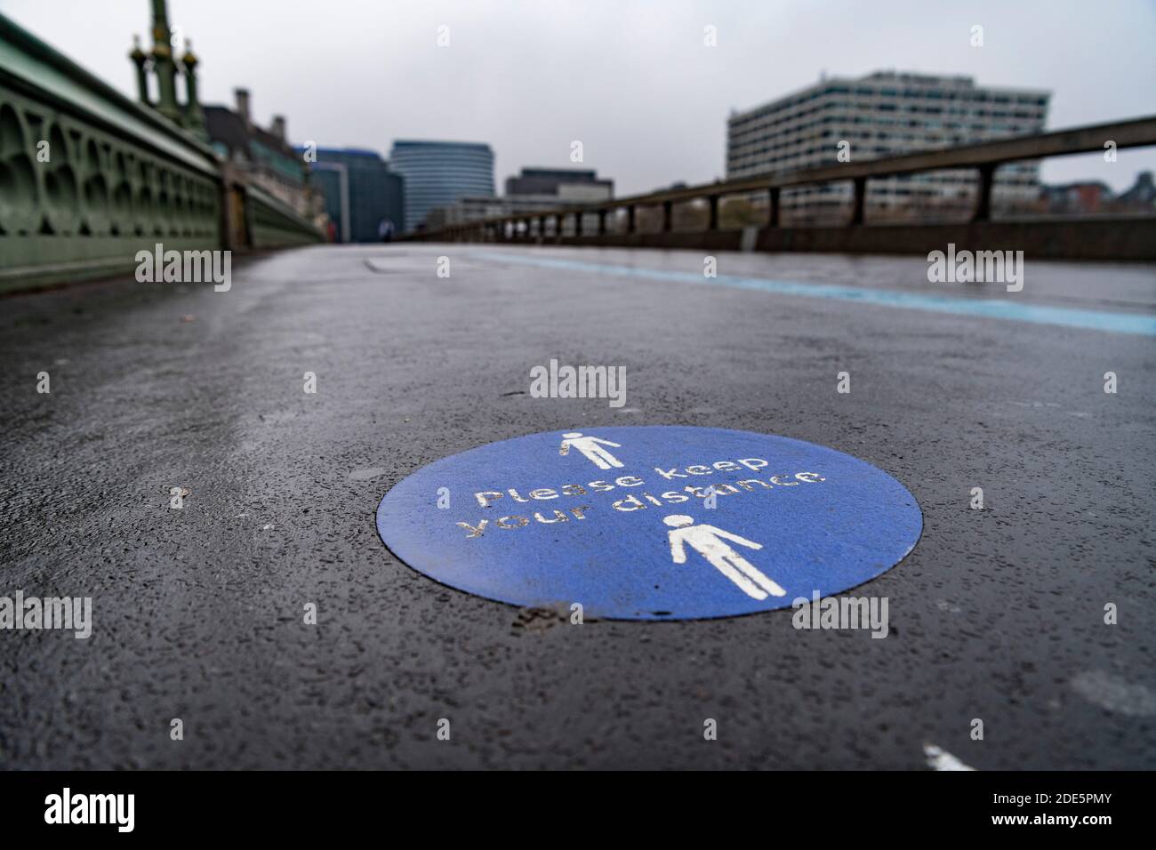 Coronavirus Covid-19 Lockdown Informationen Zeichen auf dem Bürgersteig zu halten soziale Distanz, für soziale Distanzierung in London mit leeren Straßen und ruhigen verlassenen Straßen an Westminster Bridge, England, Großbritannien Stockfoto