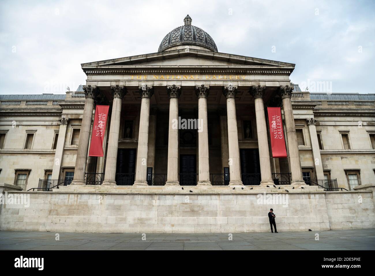 Ruhig und leer Central London in Covid-19 Coronavirus Lockdown mit einer Person zu Fuß in der National Gallery am Trafalgar Square, eine beliebte Touristenattraktion in England, Großbritannien Stockfoto