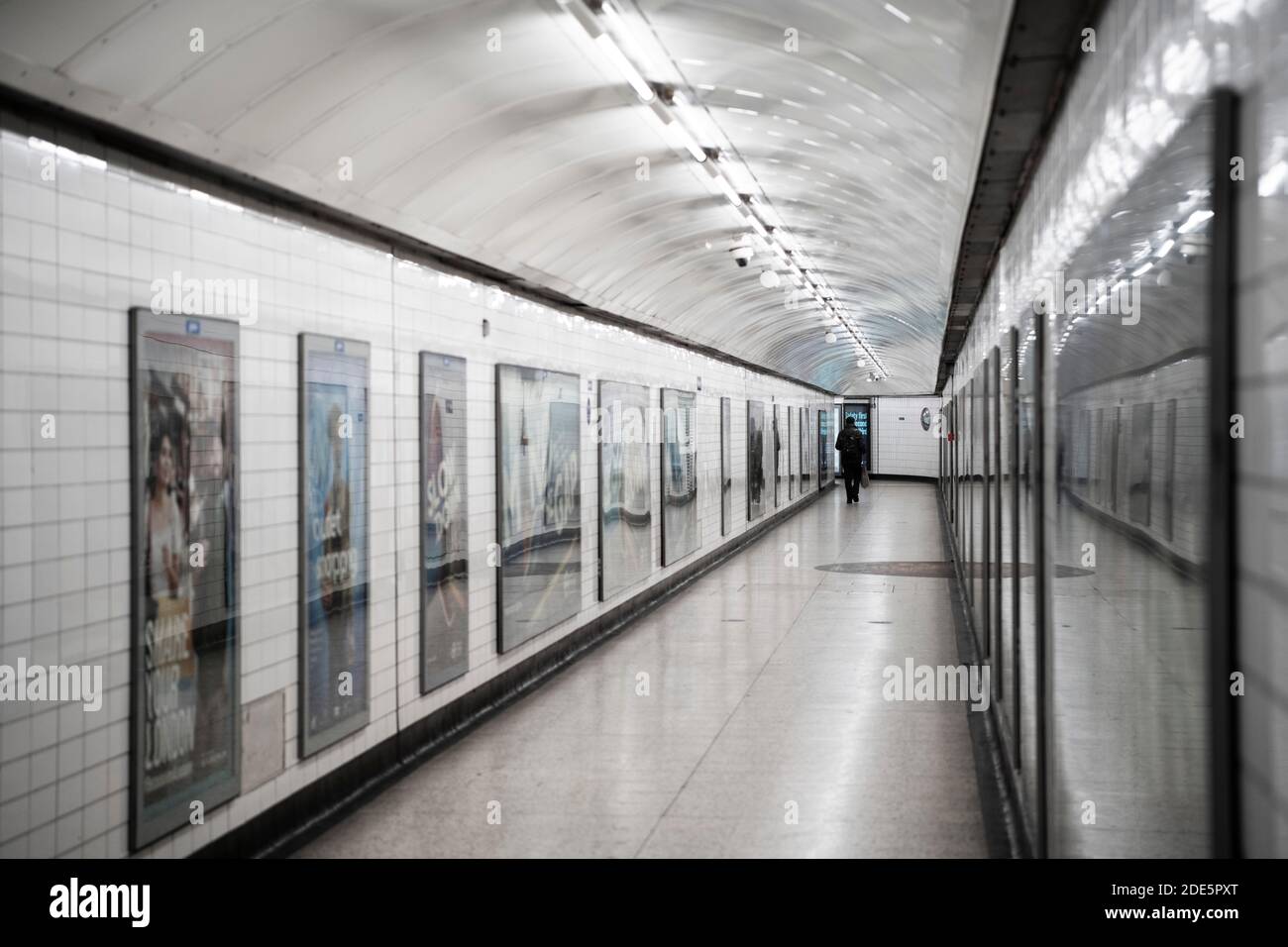 Ruhige, leere Londoner U-Bahn-Station in Coronavirus Covid-19 Pandemiesperre, mit einer einzigen Person im öffentlichen Verkehr, wenn Züge während des Reiseverbots reduziert wurden Stockfoto