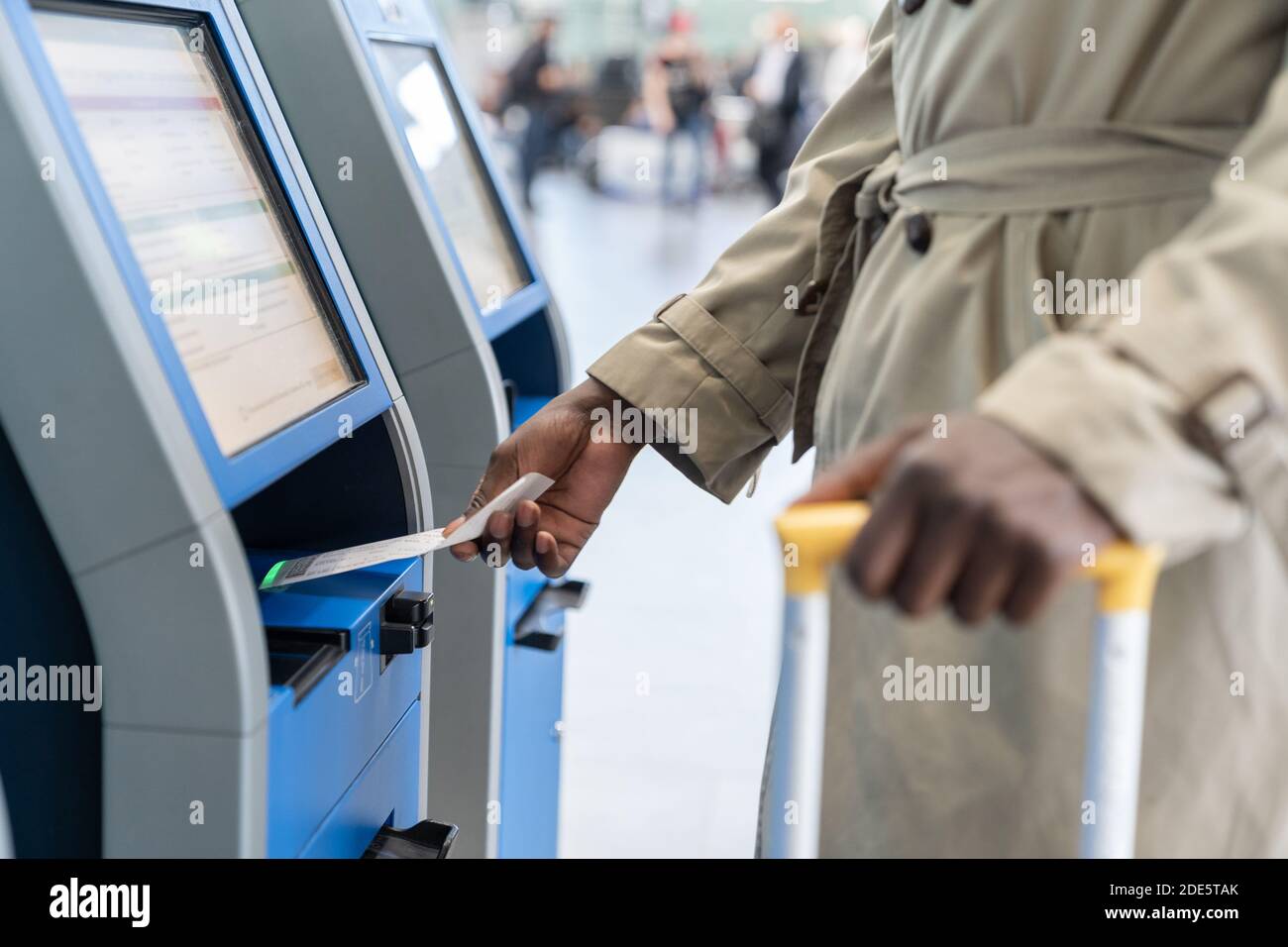 Schwarzer Reisender, der am Flughafen den Check-in-Automaten nutzt, scannt den Code auf dem Bordticket ein. Nahaufnahme. Stockfoto