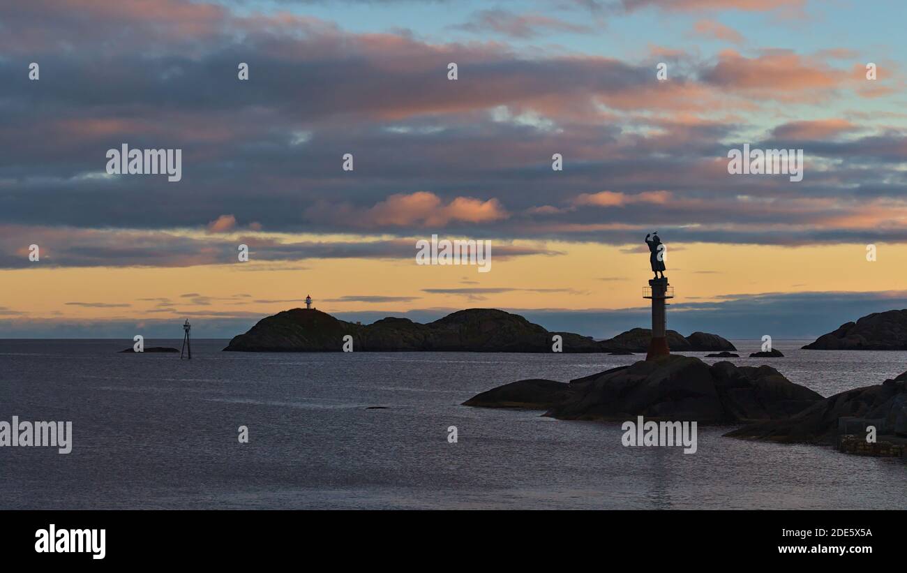 Svolvær, Austvågøya, Lofoten, Norwegen - 08-26-2020: Ruhige Abendansicht der Küste vor dem Hafen von Svolvaer mit Skulptur Fiskerkona. Stockfoto