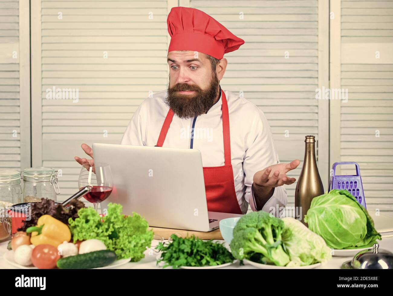 Hipster in Hut und Schürze lernen, wie man online kochen. Online-Kochunterricht.  ELearning-Konzept. Mann Koch Suche Internet Rezept Kochen Essen. Chef  Laptop kulinarische Rezepte lesen. Kochschule Stockfotografie - Alamy
