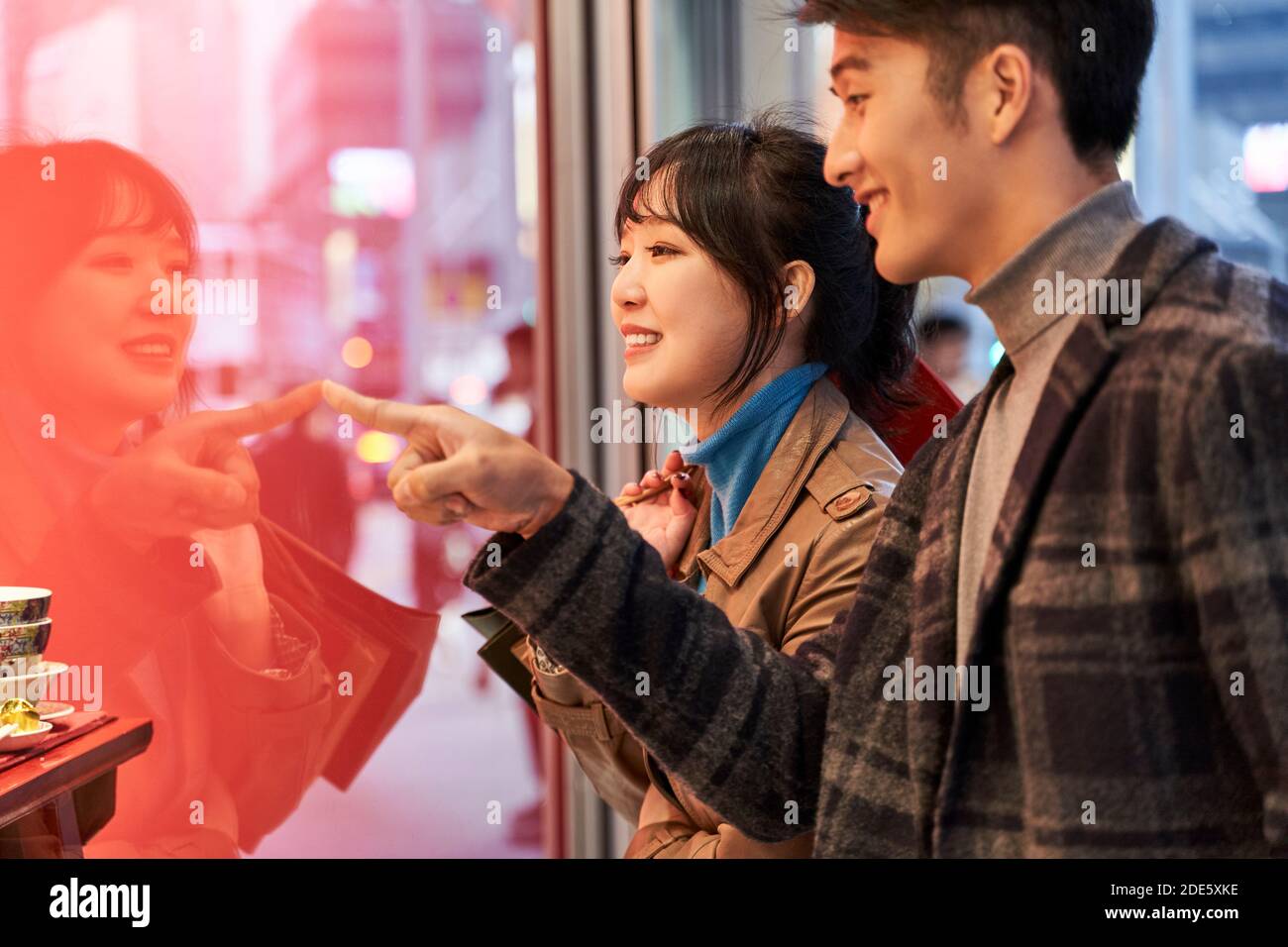 Liebevolle junge asiatische Paar Blick auf Schaufenster und sprechen Glücklich und lächelnd Stockfoto