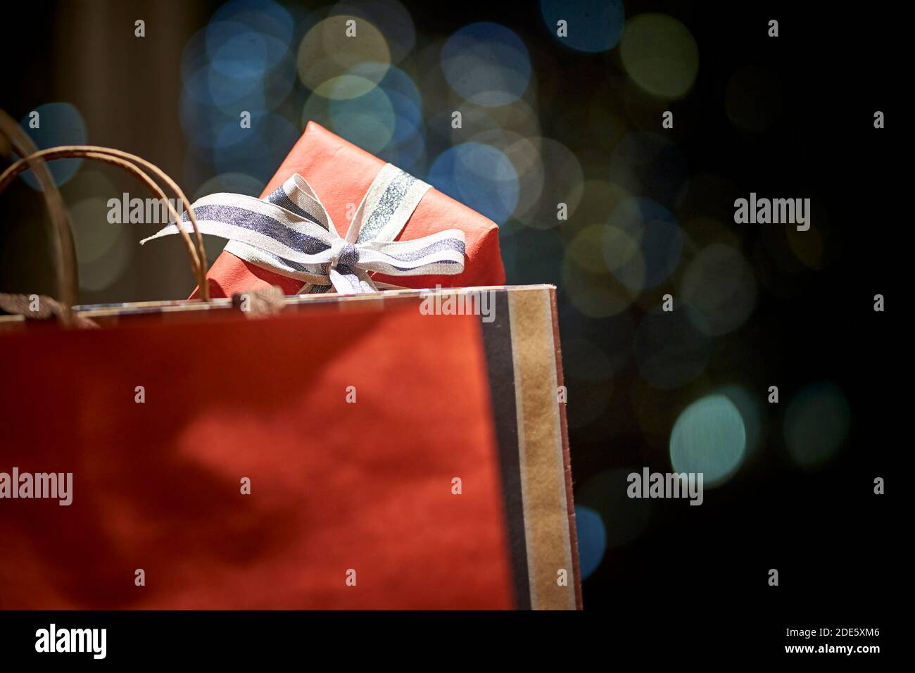 Schachtel mit eingepacktem Geschenk, das aus der Einkaufstasche aus Papier herausragt Stockfoto